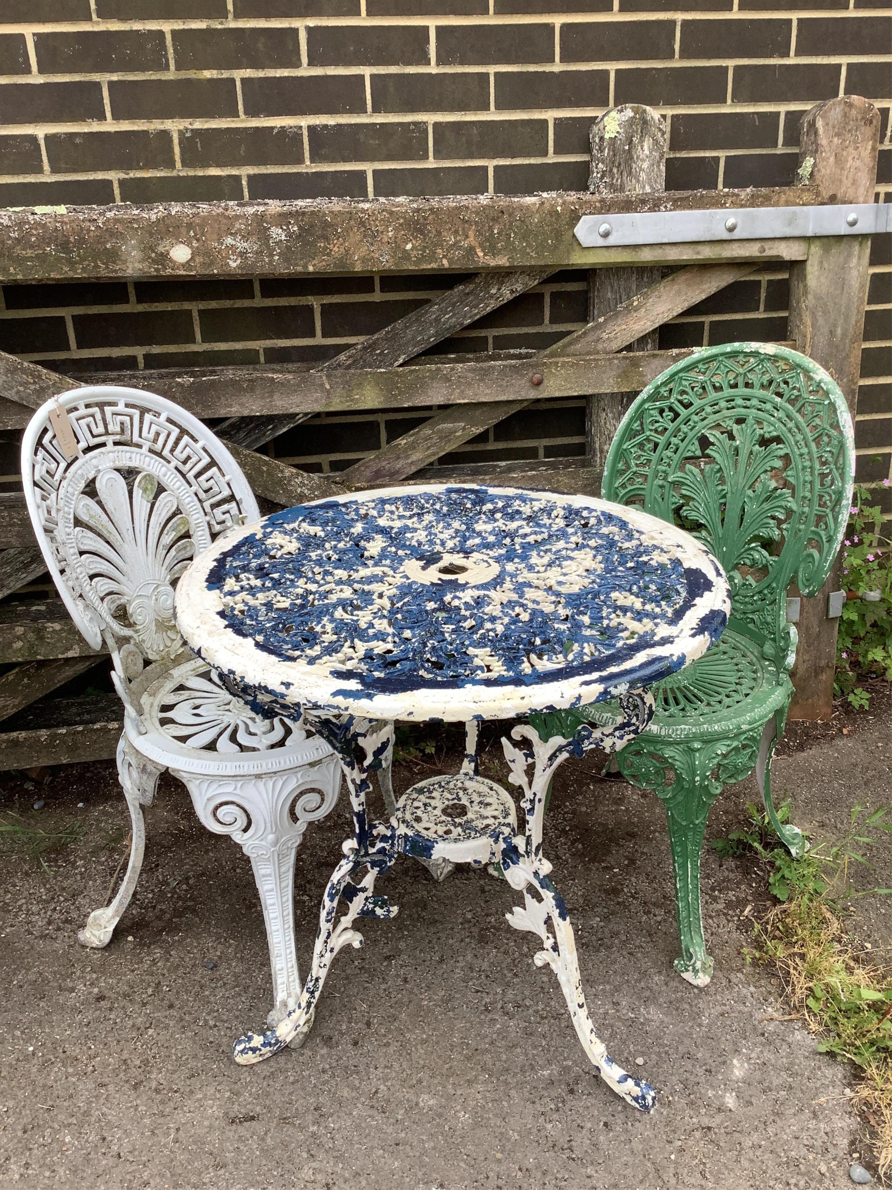 A Victorian style painted aluminium circular garden table, diameter 68cm, height 70cm and two chairs. Condition - poor to fair